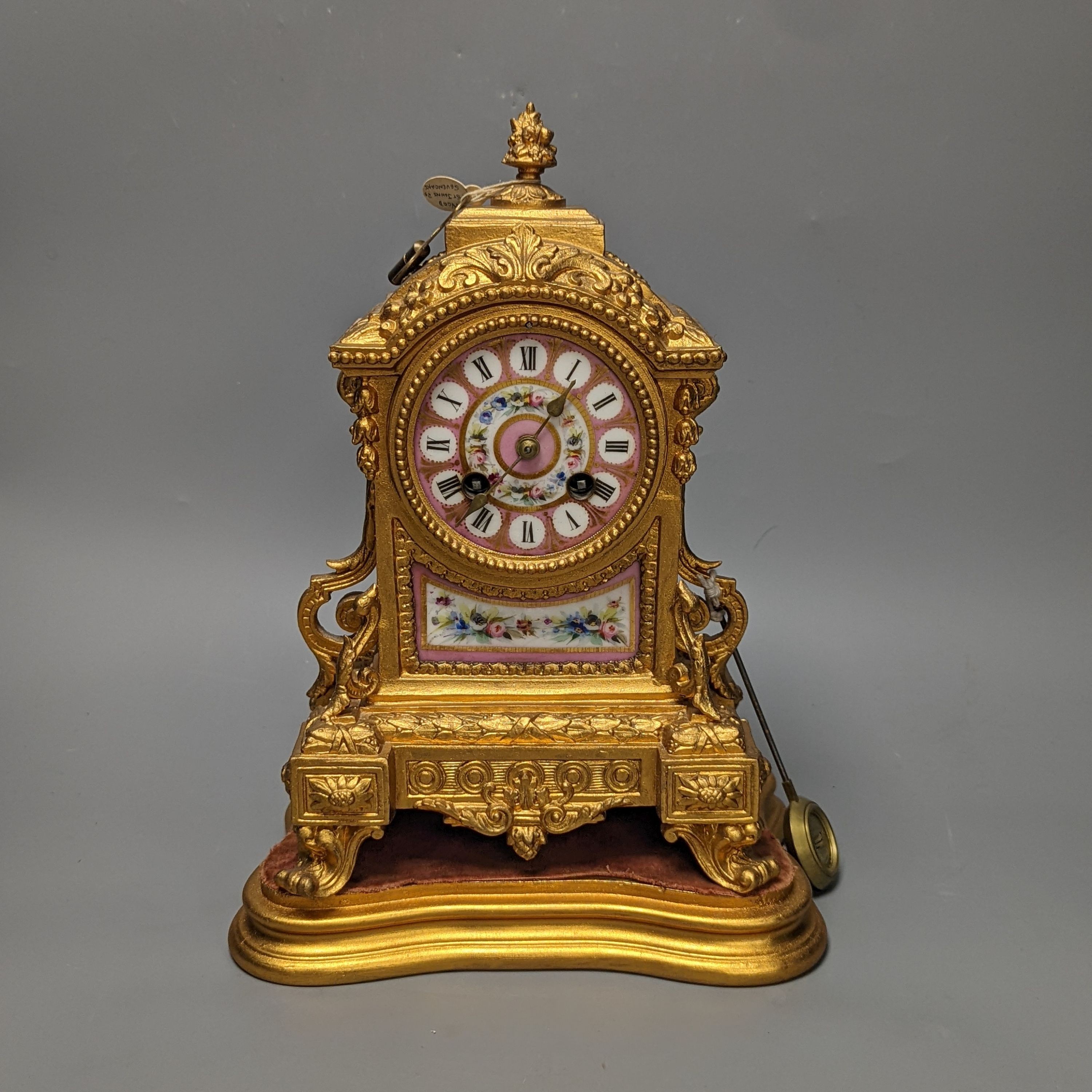 A 19th century gilt metal mantel clock on plinth with key and pendulum 30cm